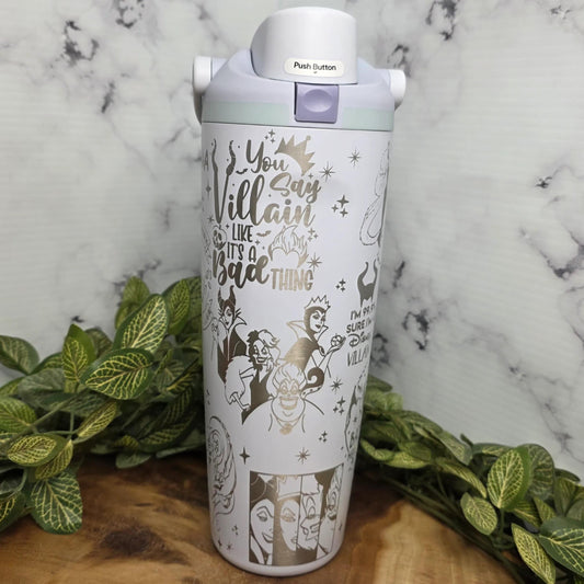 A white and silver thermos with a printed design on it, placed on a marble surface surrounded by green leaves.