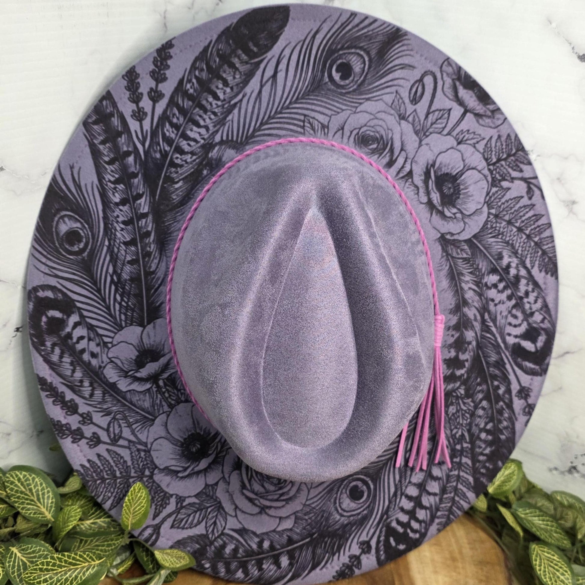Laser engraved feather design on lavender vegan suede wide brim hat with pink braided band and tassel accent